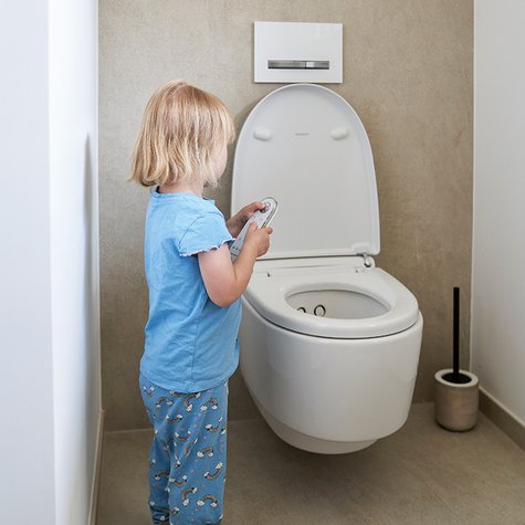 Kind steht vor Geberit AquaClean Mera Comfort Dusch-WC.