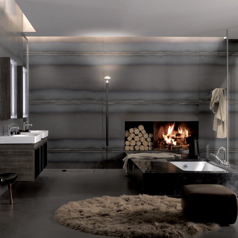 Ein Kamin und indirekte Beleuchtung schaffen Wohlfühlatmosphäre im Badezimmer.