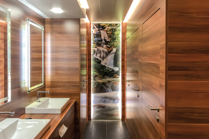 Dusch-WC-Kabinen, Waschplatz, Spiegel und ein beruhigendes Wandbild.