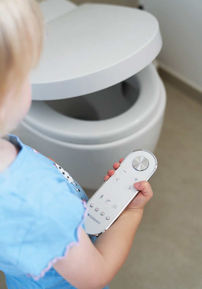 Kind steht vor Geberit AquaClean Mera Comfort Dusch-WC.
