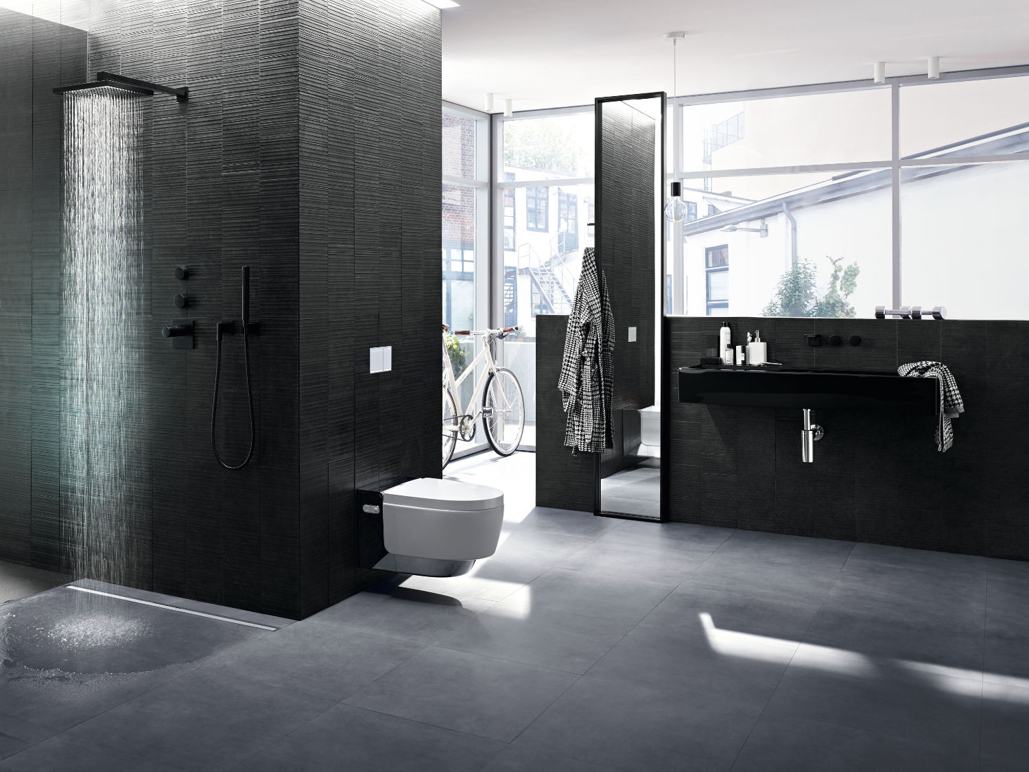 Ein in Schwarz und Grau gehaltenes Bad mit dem Geberit AquaClean Mera Dusch-WC 