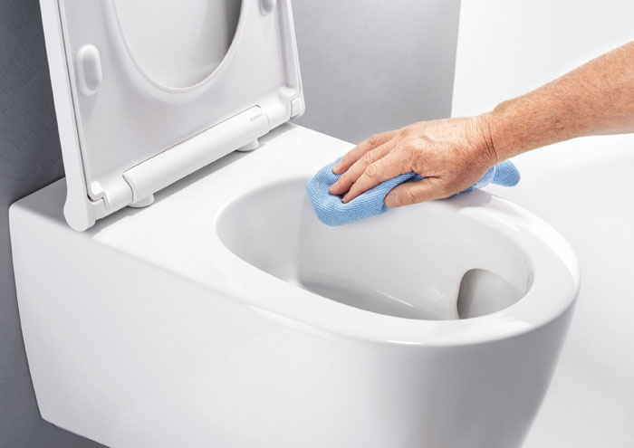 Spülrandloses WC wird mit Tuch gereinigt 