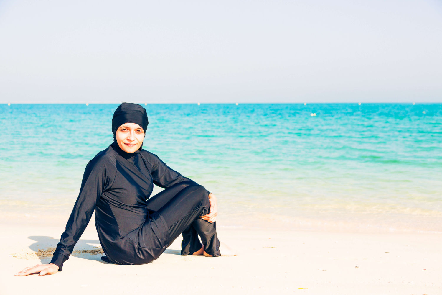 Muslimische Frau mit Burkini am Strand. 