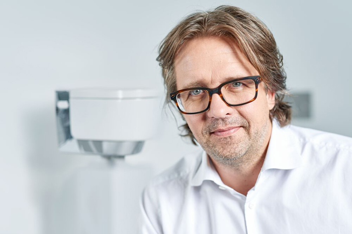 Designer Christoph Behling vor einem Geberit AquaClean Dusch-WC.