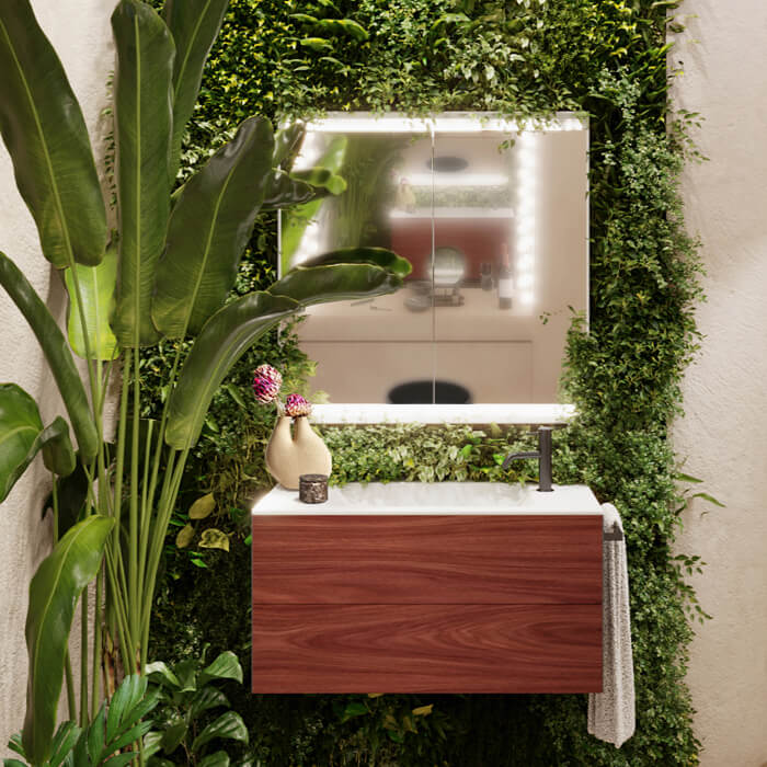 Natürliches Badezimmer mit Geberit ONE Waschtisch und Spiegelschrank vor mit Pflanzen begrünter Wand.